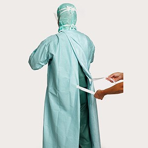 Healthcare professionals demonstrating step 6 of gown donning
