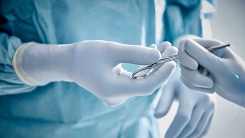 Surgeons in the operating room removing gowns