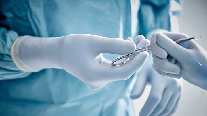 Surgeons in the operating room removing gowns